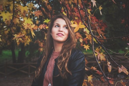 Selbstdisziplin - Frau schaut nach oben unter Herbstbaum