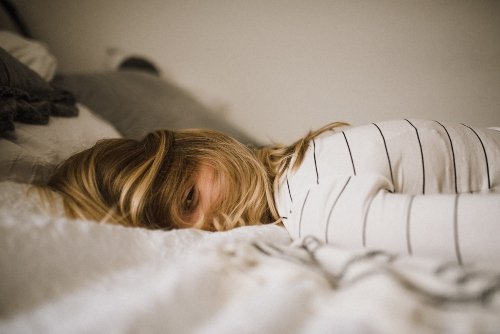 Was hilft gegen Antriebslosigkeit? Schlaf! Frau liegt auf dem Bett