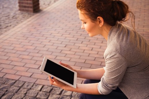 Mindset ändern - Frau sitzt mit dem Tablet in der Hand